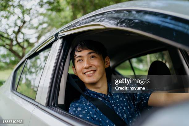 young asian man driving a car - asian man car stock pictures, royalty-free photos & images