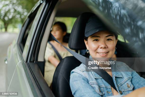 female taxi driver and passenger inside the car - taxi driver stock pictures, royalty-free photos & images