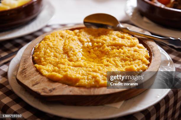 traditional corn porridge in rustic wooden bowl served on restaurant table - cornmeal stock pictures, royalty-free photos & images