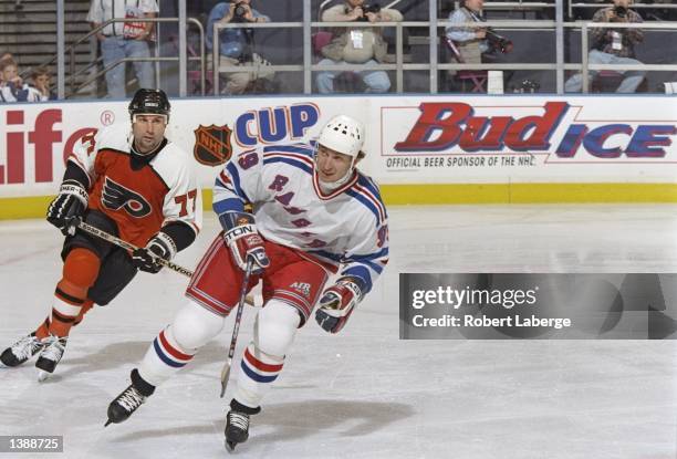 Defenseman Paul Coffey of the Philadelphia Flyers and New York Rangers center Wayne Gretzky move down the ice during a playoff game at Madison Square...