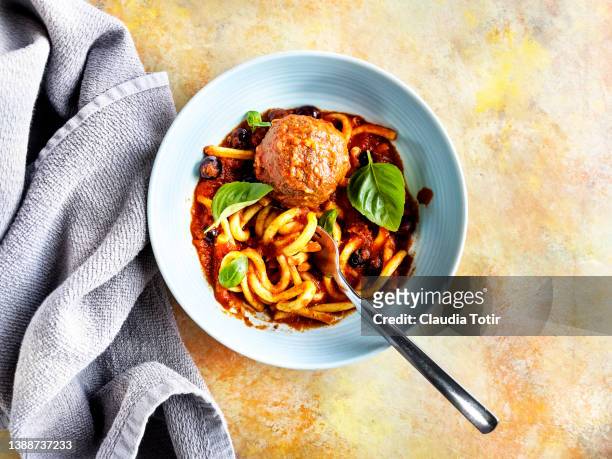 bowl of spaghetti with tomato sauce, and meatballs on yellow background - boulette de viande photos et images de collection