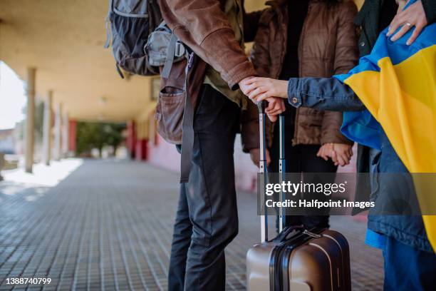 low section of ukrainian refugee family in station waiting to leave ukraine due to the russian invasion of ukraine. - refugiado imagens e fotografias de stock