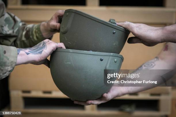 Soldiers from A Company , 2nd Battalion, The Royal Anglian Regiment sort and pack some of the surplus 84,000 ballistic helmets being shipped to armed...