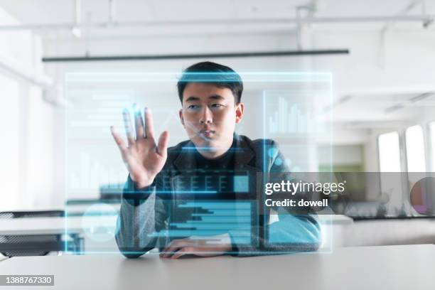 young businessman with virtual screen of financial data - young businessman using a virtual screen stockfoto's en -beelden