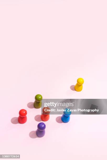 anthropomorphic multicolored wooden figures on pink - vorurteil stock-fotos und bilder