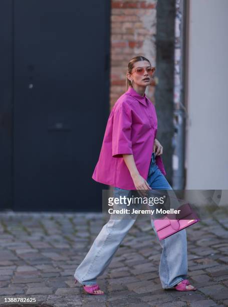 Sophia Geiss seen wearing a pink sunglasses from Chimi Eyewear, gold and silver earrings from LeGer, a pink blouse shirt from LeGer, a blue denim...