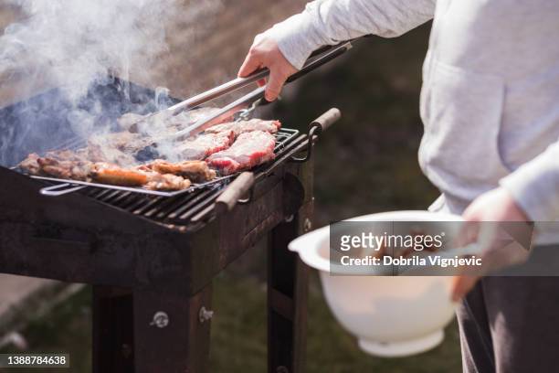 man preparing barbecue for family and friends - backyard grilling stock pictures, royalty-free photos & images