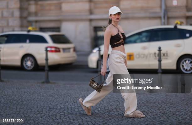 Sophia Geiss seen wearing a brown crop top from LeGer, a white LeGer cap, a beige wide leg denim jeans from LeGer, a brown vintage Fendi Baguette bag...
