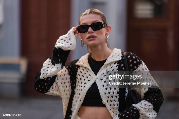 Sophia Geiss seen wearing a black Prada sunglasses, a black crop top from LeGer, a black and white striped crochet cardigan from LeGer on March 28,...
