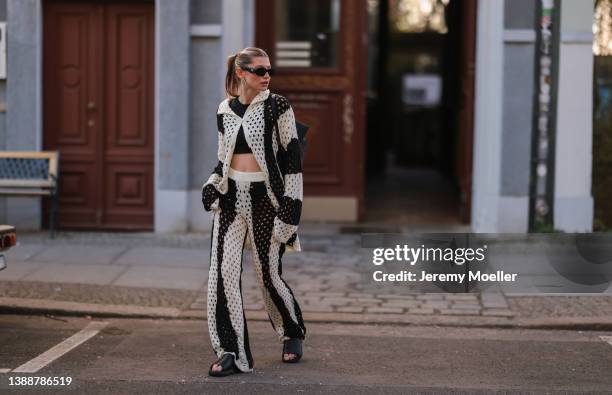 Sophia Geiss seen wearing a black Prada sunglasses, a black crop top from LeGer, a black and white striped crochet cardigan from LeGer, matching...