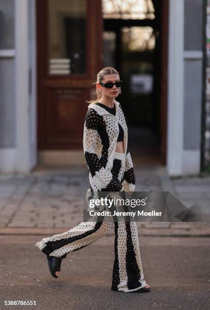 Sophia Geiss seen wearing a black Prada sunglasses, a black crop top from LeGer, a black and white striped crochet cardigan from LeGer, matching...