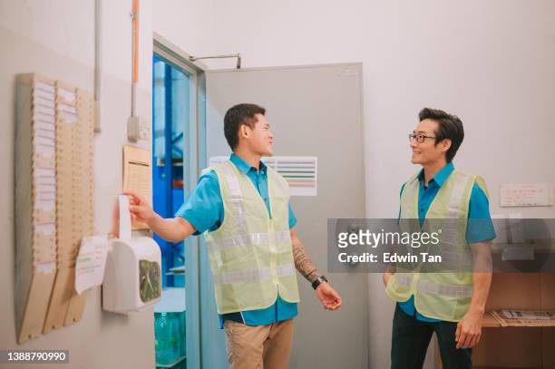operaio cinese asiatico che effettua il check-in e parla in fabbrica - primo turno foto e immagini stock