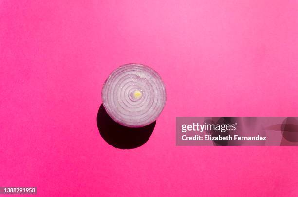 purple onion on pink background. concept of healthy vegetables. - cebolla fotografías e imágenes de stock