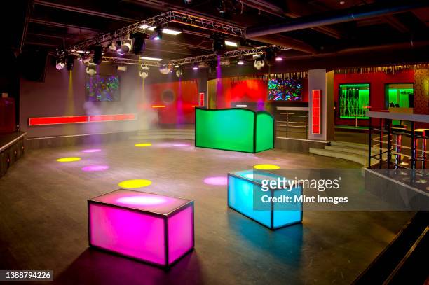 nightclub interior, colourful lighting, wall screens and light boxes on a dance floor. - light box stock pictures, royalty-free photos & images