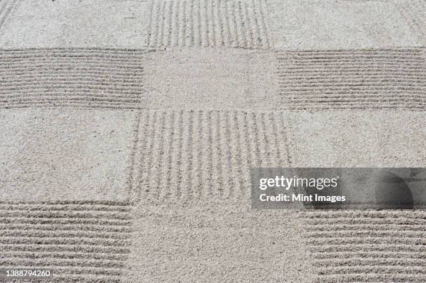 grid pattern of raked gravel at a temple - karesansui stock-fotos und bilder