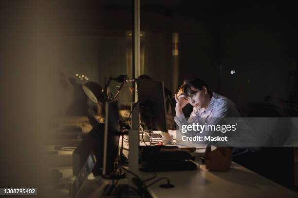 tired young businesswoman working at desk in office - stanchezza foto e immagini stock