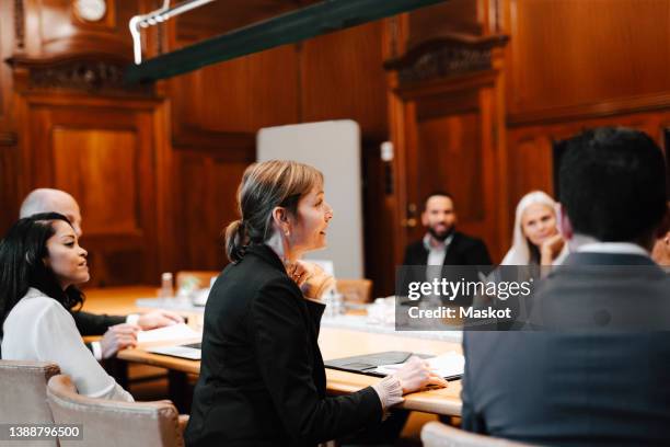 team of law colleagues discussing in board room at office during conference meeting - lawyer woman stock pictures, royalty-free photos & images