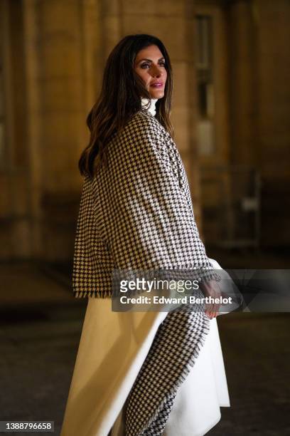 Guest wears a white ribbed turtleneck pullover, a pale yellow polar oversized long cloak, a black and white small checkered print pattern oversized...
