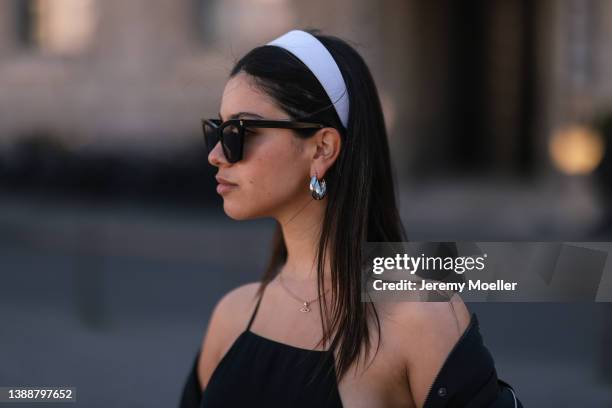 Bella Emar seen wearing a white Lacoste headband, silver earrings, black sunglasses and a black top from LeGer on March 28, 2022 in Berlin, Germany.