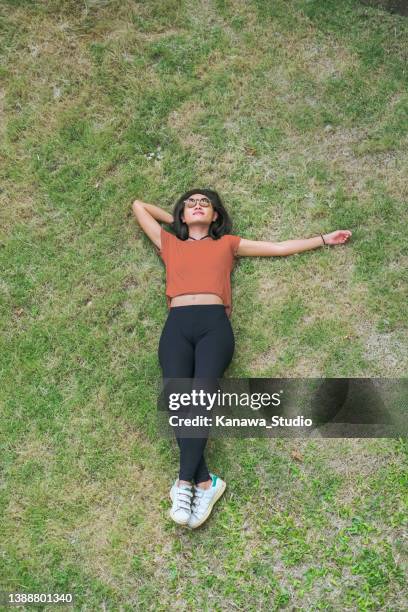 asian woman take a nap on the green grass - laying park stock pictures, royalty-free photos & images