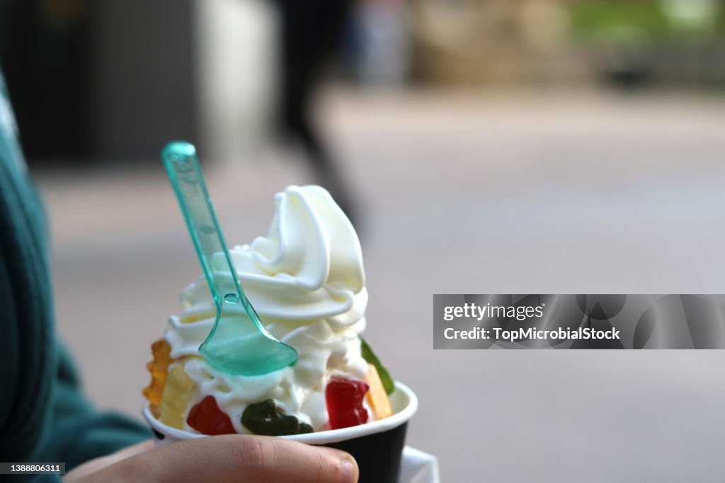 Ice cream with jelly beans in the hand of a child