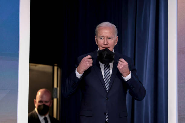 President Joe Biden removes his face mask before giving remarks on gas prices in the United States from the South Court Auditorium of the White House...