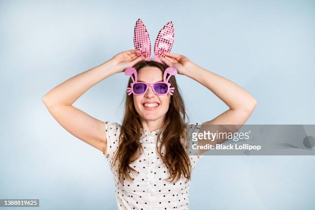cute woman with bunny ears on blue background. - bunny ears stockfoto's en -beelden