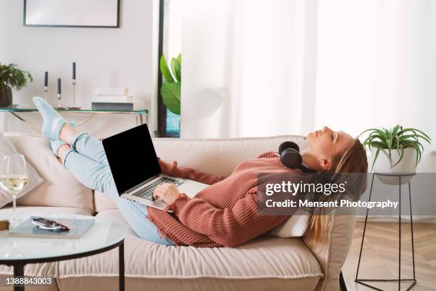 smart woman chilling at home on the sofa with gadgets - computer training stockfoto's en -beelden