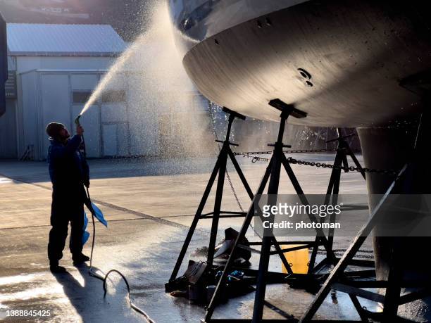 man silhouette washing the boat hull, side view - yacht bildbanksfoton och bilder
