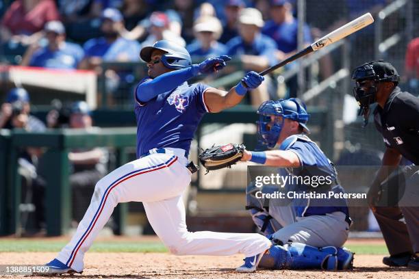 Andy Ibanez of the Texas Rangers hits a RBI single against the Los Angeles Dodgers during the second inning of the MLB spring training game at...