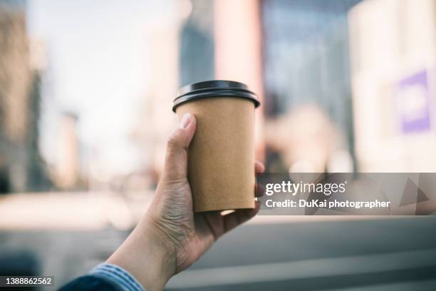 close-up of a businessman holding recycable takeaway coffee cup - coffee cup takeaway stock-fotos und bilder