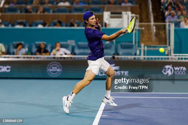 Miomir Kecmanovic of Serbia hits a forehand against Carlos Alacraz of Spain in the quarter finals of the men's singes at the Miami Open at the Hard...