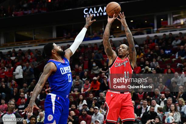 DeMar DeRozan of the Chicago Bulls shoots in the first half against Paul George of the Los Angeles Clippers at United Center on March 31, 2022 in...