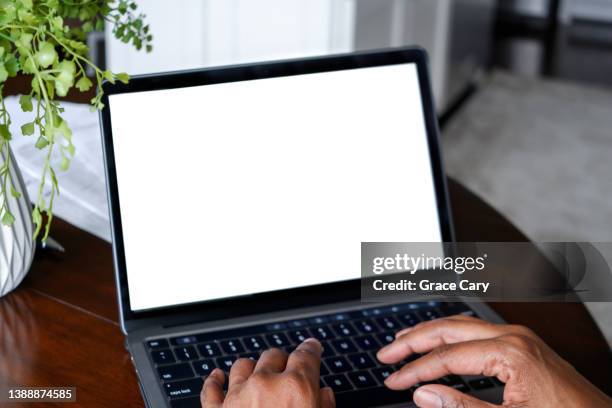 woman works from home on laptop with blank screen - laptop screen photos et images de collection