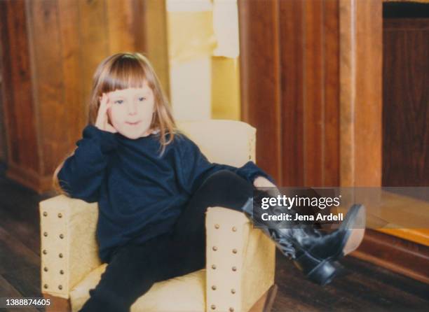 stylish child watching television wearing black cowboy boots - 80s living room fotografías e imágenes de stock