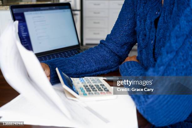 woman works on filing tax return online - tax return stockfoto's en -beelden