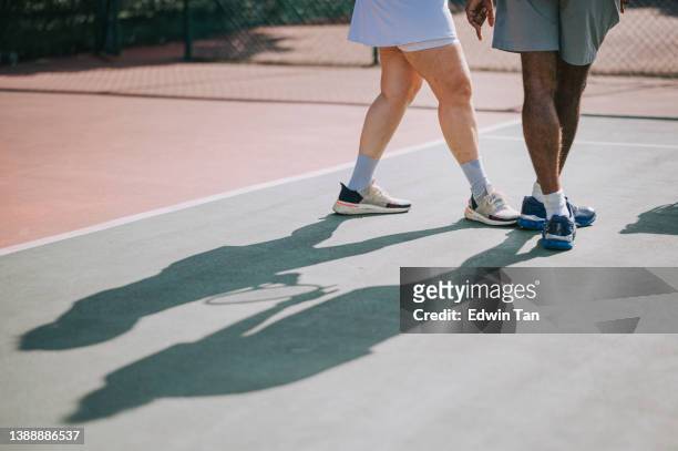 close up asian chinese mid adult woman legs aprendiendo tenis de su entrenador en la cancha de tenis durante la mañana del fin de semana - leg show fotografías e imágenes de stock