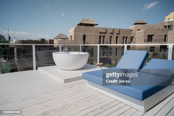 spacious and bright balcony with white bathtub and blue sofa - sun deck stock pictures, royalty-free photos & images
