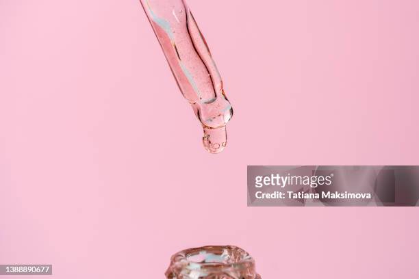 macro photography. glass pipette with face serum on pink solid background. - solid perfume stock pictures, royalty-free photos & images