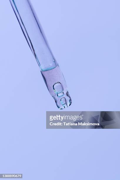 macro photography. glass pipette with face serum on purple solid background. copy space. - solid perfume stock pictures, royalty-free photos & images