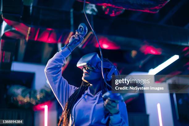 young woman playing vr video game - world showdown of esports stockfoto's en -beelden