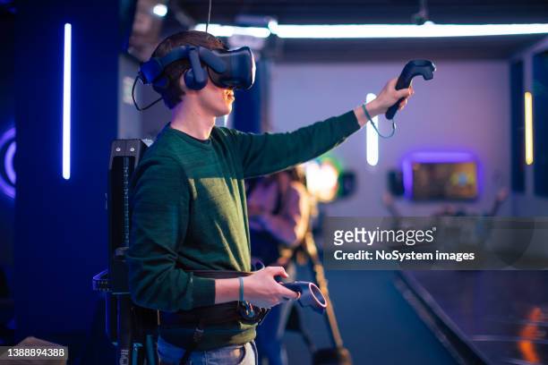 young man and woman playing vr multiplayer video game - massively multiplayer online game stock pictures, royalty-free photos & images