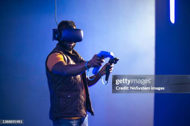 young man playing vr video game - gaming industry stock pictures, royalty-free photos & images