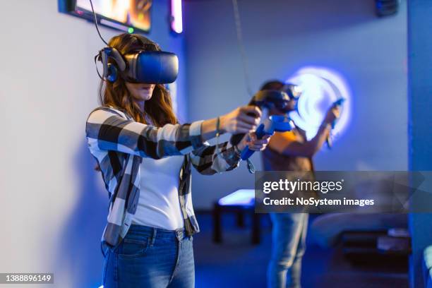 young man and woman playing vr multiplayer video game - massively multiplayer online game stock pictures, royalty-free photos & images