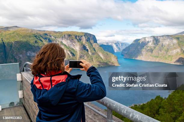 woman looking at aurlandsfjord from stegastein  viewpoint, norwway - uitkijktoren stockfoto's en -beelden