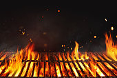 Fire embers particles over black background.  Grill Background - Empty Fired Barbecue On Black . Abstract dark glitter fire particles lights.
