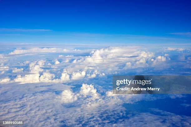 high above rain clouds, blue sky, air travel passenger view - high tech beauty stockfoto's en -beelden