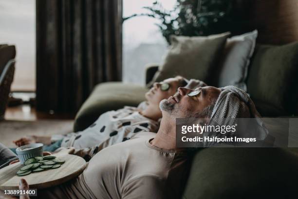 father and teen daughter applying face mask together at home. - man resting stock pictures, royalty-free photos & images