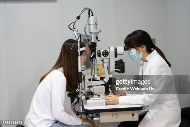 ophthalmologist examining a patient's eye in clinic - eye test equipment bildbanksfoton och bilder