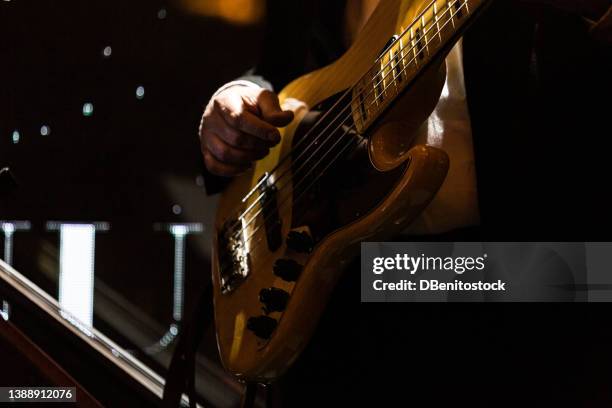 detail of a guitar being played on stage by a guitarist. concert, music, show and nightclub concept. - blues in the night stock-fotos und bilder